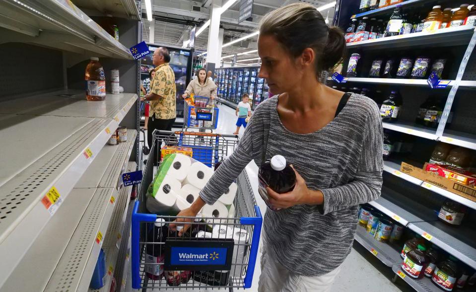 <p>Erica McMillan stocks up with what’s left on the shelves at Walmart in Oahu, Hawaii on Aug. 22, 2018, in preparation for the arrival of Hurricane Lane. (Photo: Ronen Zilberman/AFP/Getty Images) </p>