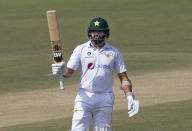 Pakistan's batsman Azhar Ali raises bat to celebrate his fifty during the second day of the first cricket test match between Pakistan and South Africa at the National Stadium in Karachi, Pakistan, Wednesday, Jan. 27, 2021. (AP Photo/Anjum Naveed)