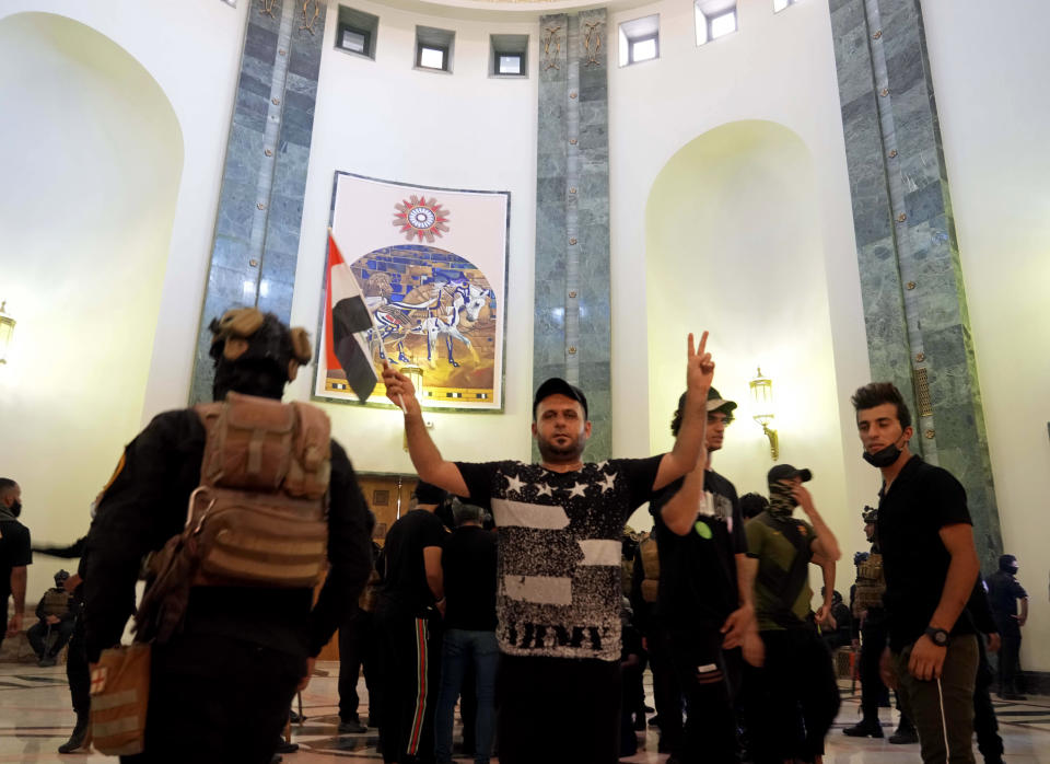 Supporters of Shiite cleric Muqtada al-Sadr enter the Government Palace during a demonstration in Baghdad, Iraq, Monday, Aug. 29, 2022. Al-Sadr, a hugely influential Shiite cleric announced he will resign from Iraqi politics and his angry followers stormed the government palace in response. The chaos Monday sparked fears that violence could erupt in a country already beset by its worst political crisis in years. (AP Photo/Hadi Mizban)