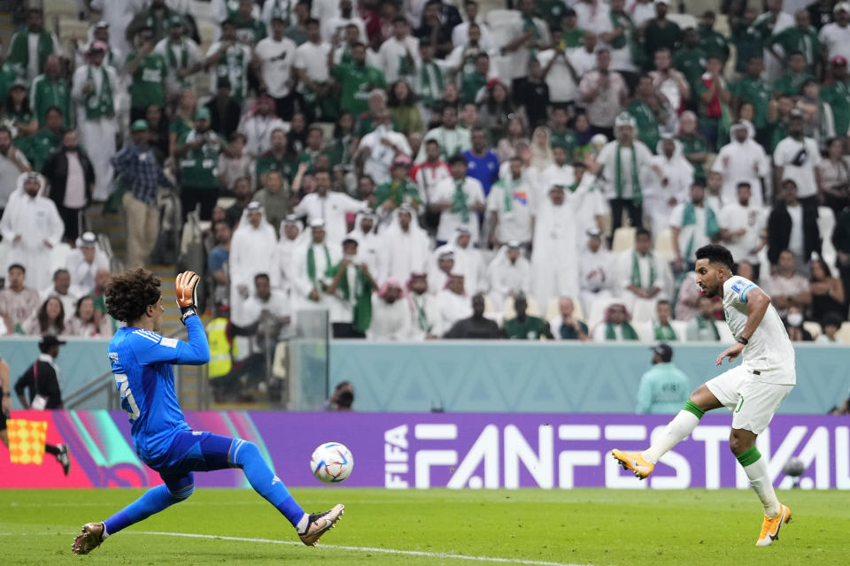 Saudi Arabia's Salem Al-Dawsari, right, scores his sides first goal past Mexico's goalkeeper Guillermo Ochoa during the World Cup group C soccer match between Saudi Arabia and Mexico, at the Lusail Stadium in Lusail, Qatar, Wednesday, Nov. 30, 2022. (AP Photo/Manu Fernandez)