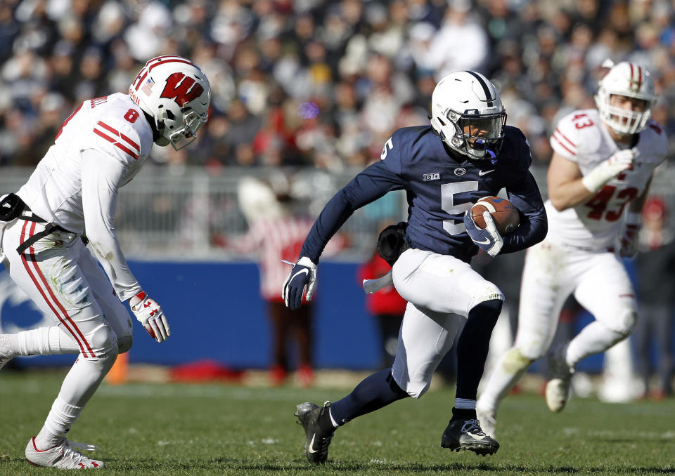 Penn State's Jahan Dotson (5) takes off running after a catch as Wisconsin's Deron Harrell (8) gives chase during the first half of an NCAA college football game in State College, Pa., Saturday, Nov. 10, 2018. (AP Photo/Chris Knight)