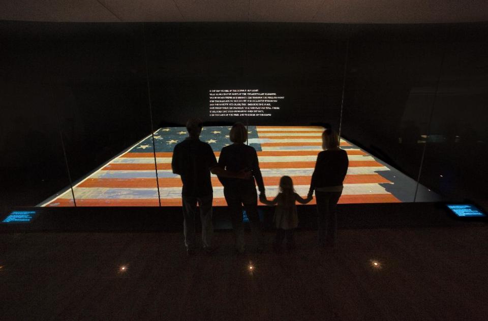 This handout photo provided by the Smithsonian Institution, taken in Nov. 2008, shows a family viewing the Star Spangled Banner at the Smithsonian's National Museum of American History in Washington. The original, handwritten manuscript of “The Star-Spangled Banner” and the flag that inspired the song’s lyrics will be displayed together at the Smithsonian in Washington, what is believed to be the first time the historic pieces have been shown side-by-side, on Flag Day, June 14, through July 6. (AP Photo/Hugh Talman, Smithsonian Institution)