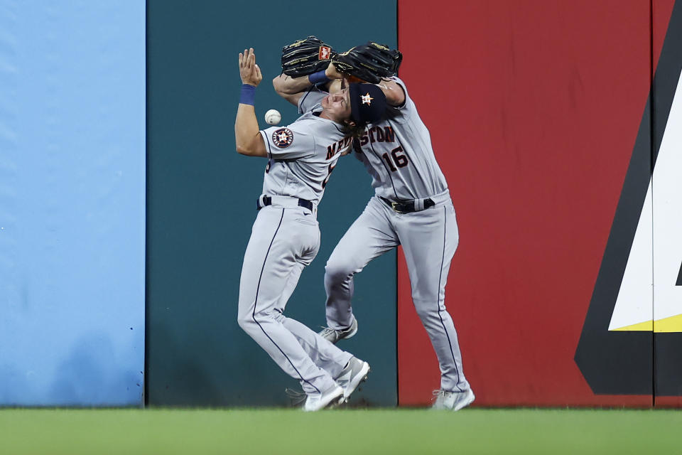 Houston Astros left fielder Aledmys Diaz, left, and center fielder Jake Meyers collide while going for a ball hit by Cleveland Guardians' Austin Hedges during the eighth inning of a baseball game Thursday, Aug. 4, 2022, in Cleveland. Hedges reached on an error by Diaz. (AP Photo/Ron Schwane)