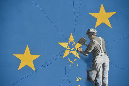 A section of an artwork attributed to street artist Banksy, depicting a workman chipping away at one of the 12 stars on the flag of the European Union, is seen on a wall in the ferry port of Dover, Britain May 7, 2017. REUTERS/Hannah McKay