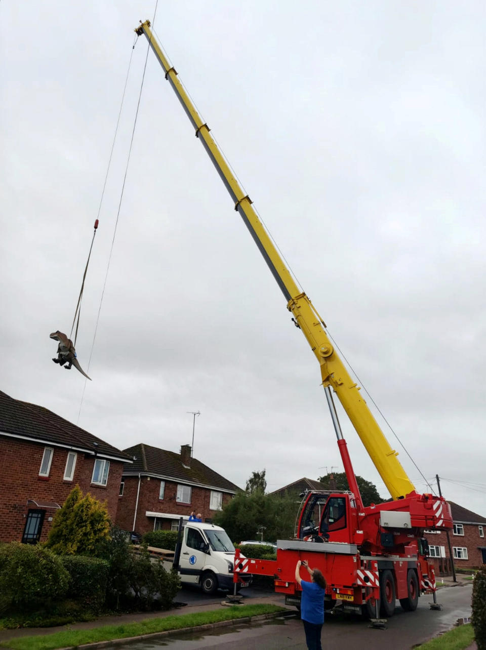 A wacky husband shocked his wife who wanted to brighten up their garden with a gnome - by installing a 12ft-tall replica of a T-REX on the patio. Adrian Shaw, 52, snapped up the 14-stone resin and fiberglass dinosaur and hired a crane to winch it into position on Thursday (3/9). He came up with the madcap-scheme after wife Deborah, 53, begged him to clean up the back garden of their home in Leamington Spa, Warks. The IT analyst paid £1,600 for the replica of the terrifying beast, which he named ‘Dave’ and put it on the patio.