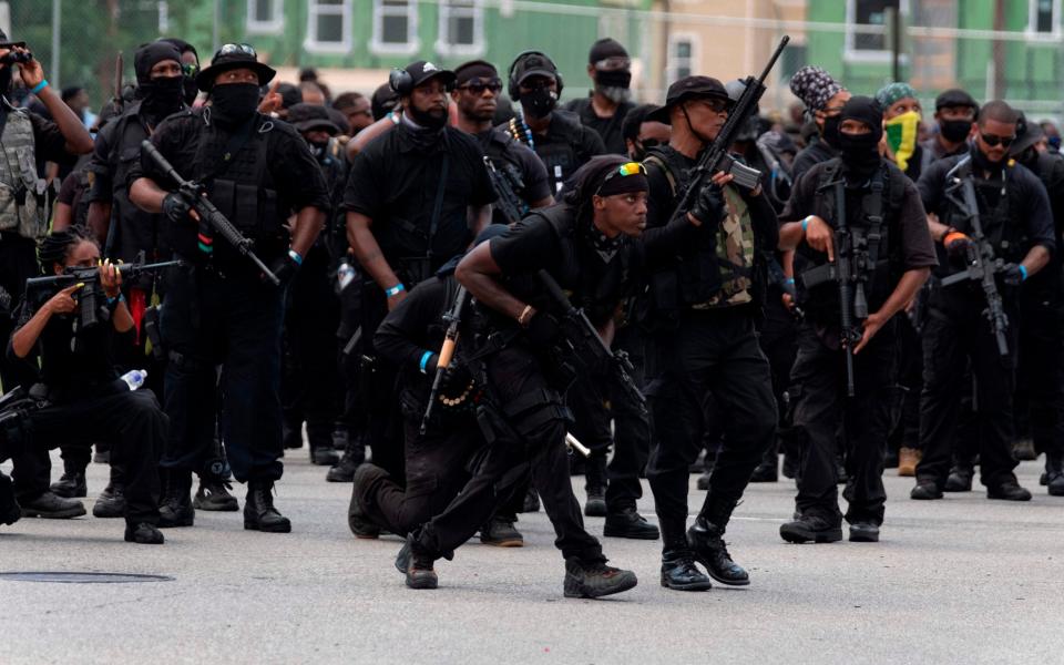 Members of the militia march during a rally to protest the killing of Breonna Taylor - AFP