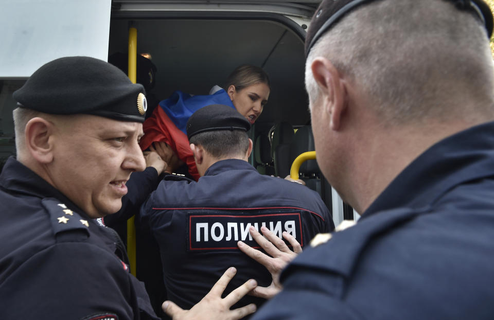 Police officers detain an opposition candidate and lawyer at the Foundation for Fighting Corruption Lyubov Sobol prior to an unsanctioned rally in the center of Moscow, Russia, Saturday, July 27, 2019. OVD-Info, an organization that monitors political arrests, said about 50 people had been detained by 1:30 p.m. Saturday (1030 GMT), a half-hour before the protest against the exclusion of opposition figures from the ballot for city council elections was to start. (AP Photo/Dmitry Serebryakov)