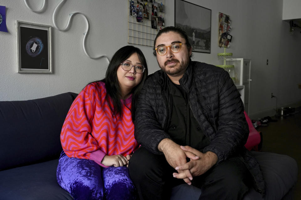 Celina Chanthanouvong and her partner Richard Flores pose in their apartment in Emeryville, Calif., on June 2, 2023. After a payment pause that has lasted more than three years, more than 40 million student loan borrowers will be on the hook for payments starting in late August. The pause in repayment has been a lifeline keeping 25-year-old Chanthanouvong afloat. (AP Photo/Terry Chea)