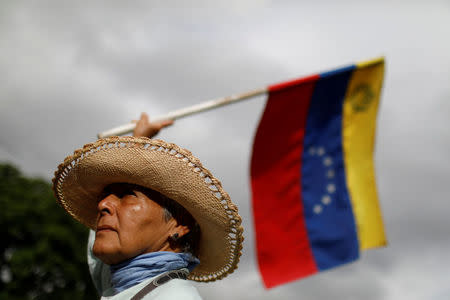 An opposition supporter waves a Venezuelan national flag as she blocks a highway during a protest against Venezuelan President Nicolas Maduro's government in Caracas, Venezuela May 15, 2017. REUTERS/Carlos Garcia Rawlins