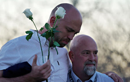 Will Beck, a survivor of the attack at Columbine high school, hugs Lee Andres (R) at the Columbine memorial a day before the school shooting's 20th anniversary, in Littleton, Colorado, U.S., April 19, 2019. REUTERS/Rick Wilking