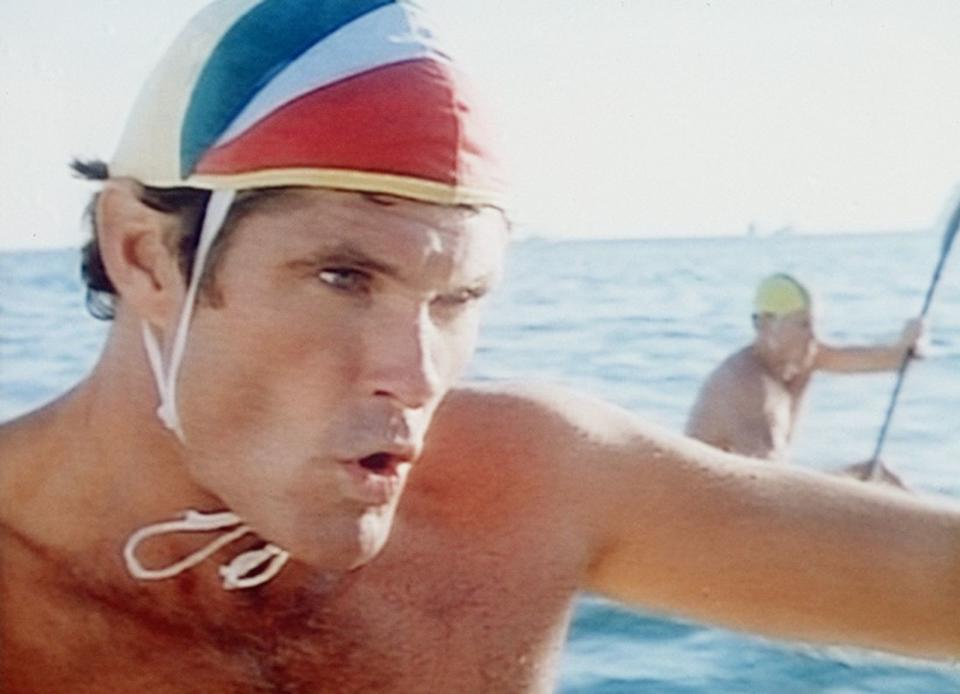 Das musste beim Schwimmen aber natürlich auch geschützt werden. So entschied sich David Hasselhoff für eine bunte Bademütze, damit seine Haare nicht nass wurden. Wirkt aus heutiger Sicht etwas museal. (Bild: RTL NITRO / Betafilm)