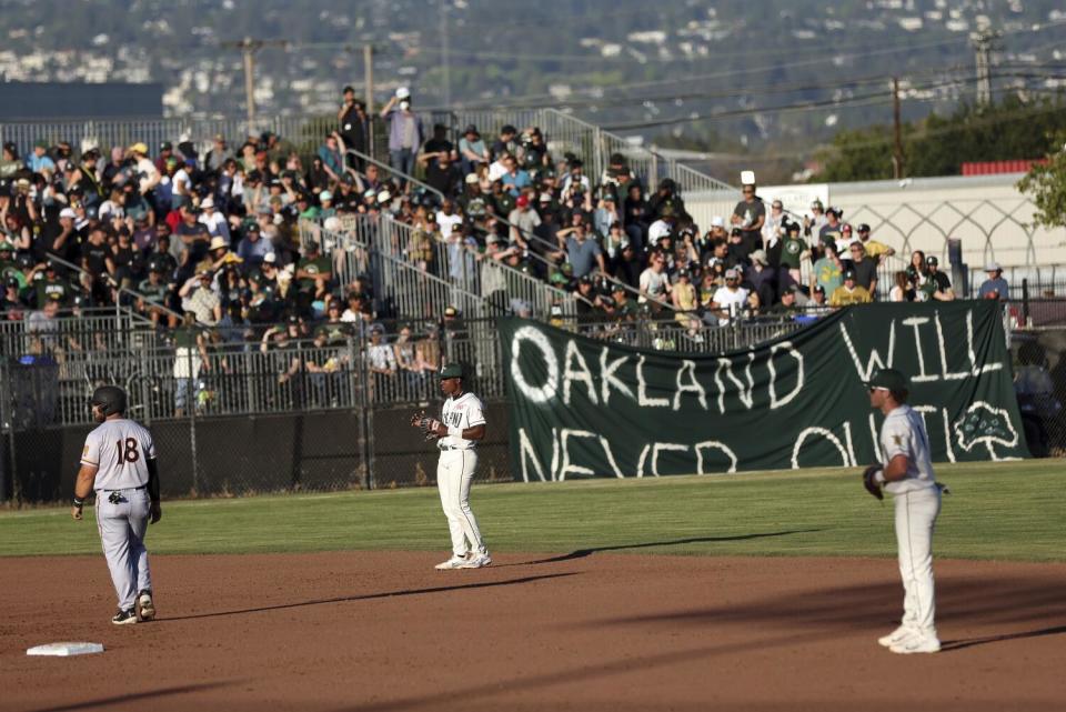 "Oakland Will Never Quit" banner hangs on a fence during Oakland Ballers' inaugural home opener.