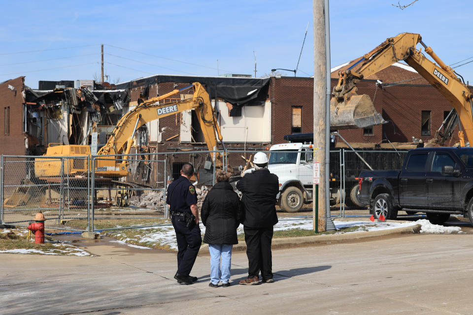 City of Kent Mayor Jerry Fiala and others watch as demolition begins on the old City of Kent Police Department building located at the corner of Water Street and Haymaker Parkway Monday morning.