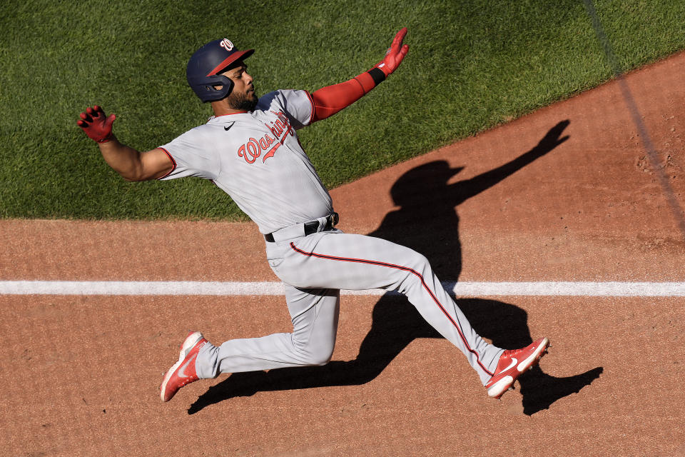 Washington Nationals' Jeimer Candelario (9) slides home to score on a double hit by Corey Dickerson during the sixth inning of a baseball game against the Kansas City Royals Saturday, May 27, 2023, in Kansas City, Mo. (AP Photo/Charlie Riedel)