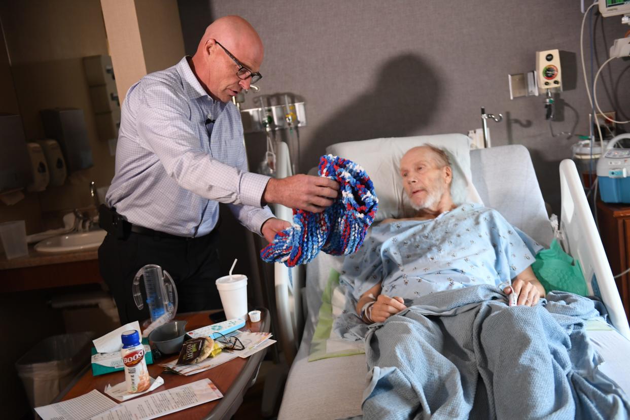 Robert Sommer presents Doug Bultje with a knitted blanket on Friday, Nov. 10, 2023 at Sanford USD Medical Center in Sioux Falls, South Dakota.