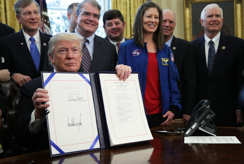 Trump signed a bill authorizing funding for NASA in a bill signing ceremony as NASA astronaut Tracy Caldwell Dyson (4th L) and legislators including Rep. Brian Babin (R-Texas) (L), and Rep. John Culberson (R-Texas) (2nd L) looked on in the Oval Office.