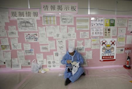 A worker prepares for work in front of information board inside the emergency operation center at Tokyo Electric Power Co. (TEPCO)'s tsunami-crippled Fukushima Daiichi nuclear power plant in Fukushima prefecture in this February 20, 2012 file photo. REUTERS/Issei Kato/Files