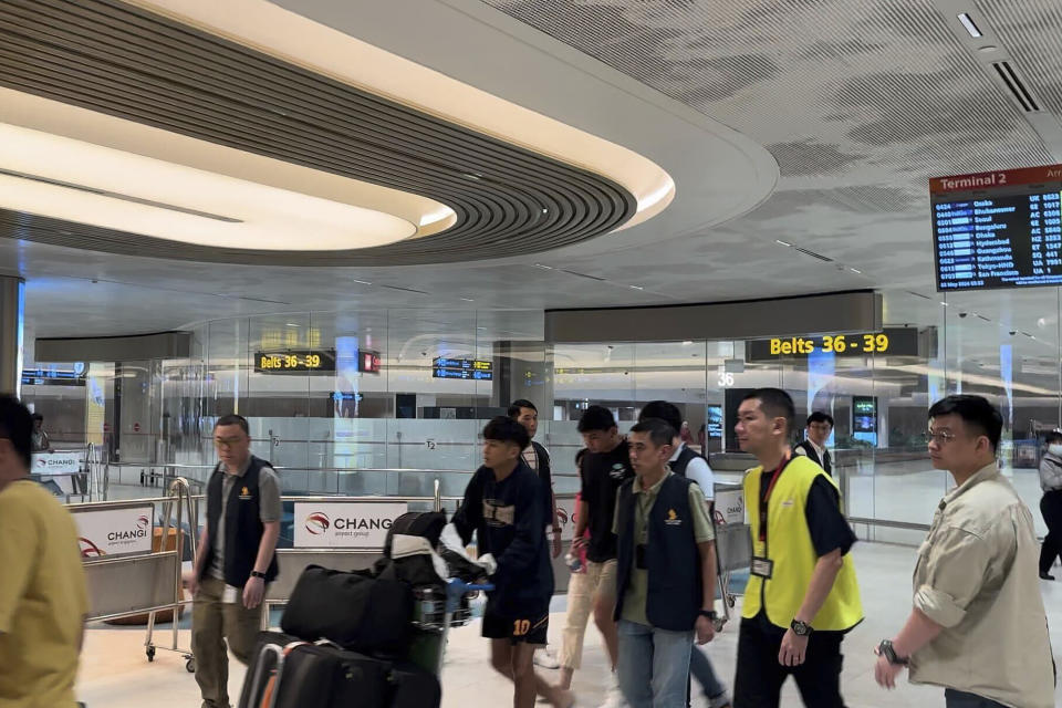 A passenger, center, arrives from Bangkok at a Singapore airport Wednesday, May 22, 2024. A Singapore Airlines flight from London's Heathrow airport to Singapore was diverted and landed in stormy weather in Bangkok on Tuesday. (AP Photo)