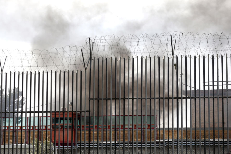 Smoke billows from Rebibbia prison following inmates' protests, in Rome, Monday, March 9, 2020. Italian penitentiary police say six inmates protesting coronavirus containment measures at the northern Italian prison of Modena have died after they broke into the infirmary and overdosed on methadone. The protest Sunday in Modena was among the first of more than two-dozen riots at Italy's overcrowded lock-ups that grew Monday. (Cecilia Fabiano/LaPresse via AP)