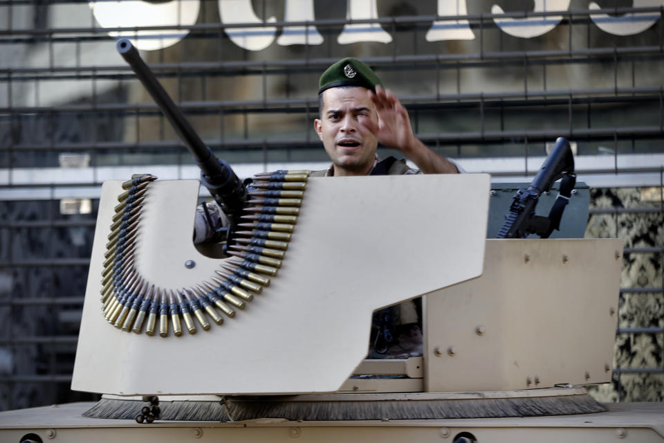 A Lebanese army soldier gestures as he stands guard at the site where deadly clashes that erupted Thursday along a former 1975-90 civil war front-line between Muslim Shiite and Christian areas, in Ain el-Remaneh neighborhood, Beirut, Lebanon, Friday, Oct. 15, 2021. Schools, banks and government offices across Lebanon shut down Friday after hours of gun battles between heavily armed militias killed six people and terrorized the residents of Beirut. (AP Photo/Bilal Hussein)