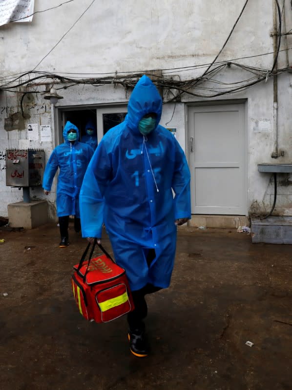 Volunteers of the Edhi Foundation, a non-profit social welfare programme, wear raincoats and boots as they pose during a mock drill on handling suspected carriers of the coronavirus disease (COVID-19), in Karachi, Pakistan