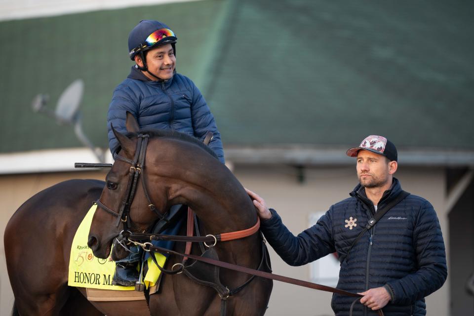 Assistant exercise rider Morelio Garcia (left) and trainer Whit Beckman hold 2024 Kentucky Derby contender Honor Marie as they wait for the track to open April 21.