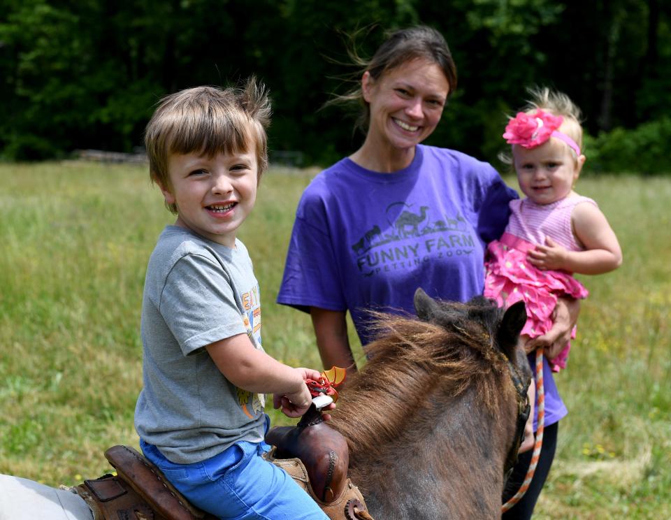 Tabatha Roberts, owner of Funny Farm Petting Zoo, with her children Carson, left, and Savannah May 19, 2023, in Berlin, Maryland.