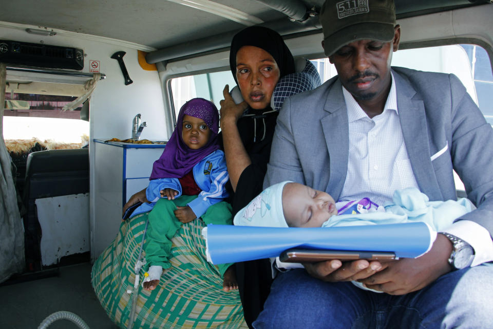 A mother and father carry their wounded child to be airlifted to the Turkish capital for treatment after they were injured in Saturday's car bomb blast in Mogadishu, Somalia, Sunday, Dec. 29, 2019. A truck bomb exploded at a busy security checkpoint in Somalia's capital Saturday morning, killing at least 79 people including many students, authorities said. It was the worst attack in Mogadishu since the devastating 2017 bombing that killed hundreds. (AP Photo/Farah Abdi Warsameh)