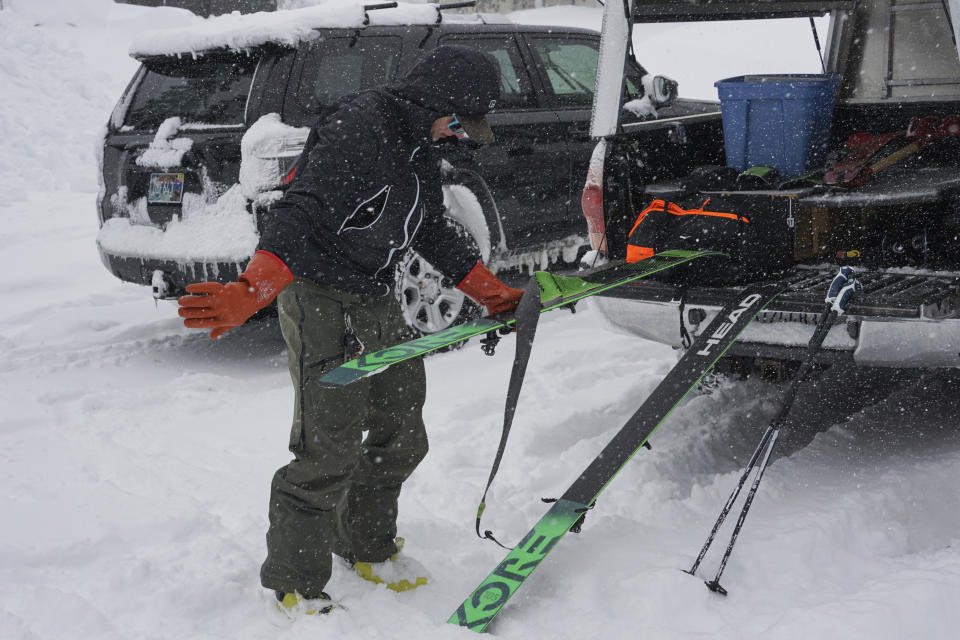 A skier puts skins on his skis before heading into the backcountry during a blizzard Sunday, March 3, 2024, in Olympic Valley, Calif. (AP Photo/Brooke Hess-Homeier)