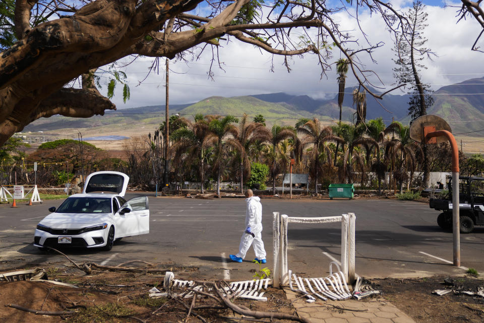 FILE - The Rev. Ai Hironaka, resident minister of the Lahaina Hongwanji Mission, walks in the parking lot as he visits his temple and residence destroyed by wildfire, Thursday, Dec. 7, 2023, in Lahaina, Hawaii. An acute housing shortage hitting fire survivors on the Hawaiian island of Maui is squeezing out residents even as they try to overcome the loss of loved ones, their homes and their community. (AP Photo/Lindsey Wasson, File)