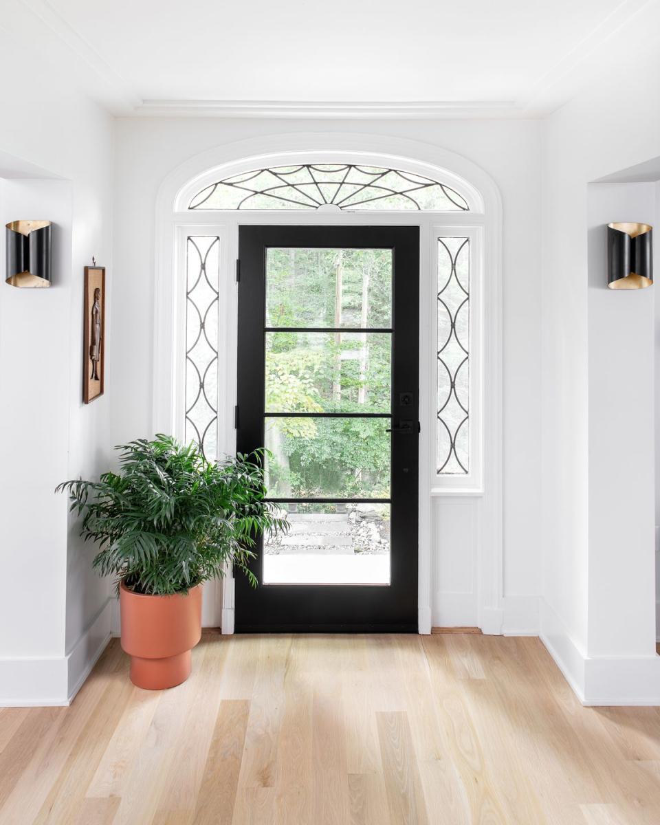 entryway with a black door and potted plant