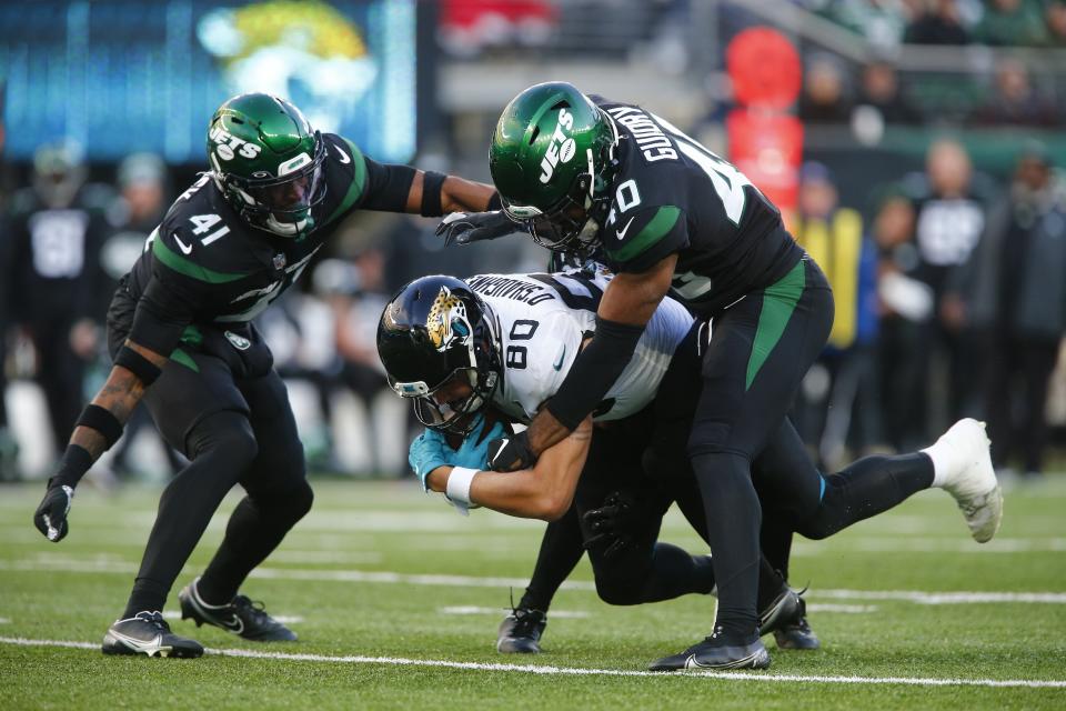 Jacksonville Jaguars' James O'Shaughnessy is tackled by New York Jets' Javelin Guidry (40) and Jason Pinnock (41) during the second half of an NFL football game Sunday, Dec. 26, 2021, in East Rutherford, N.J. (AP Photo/John Munson)