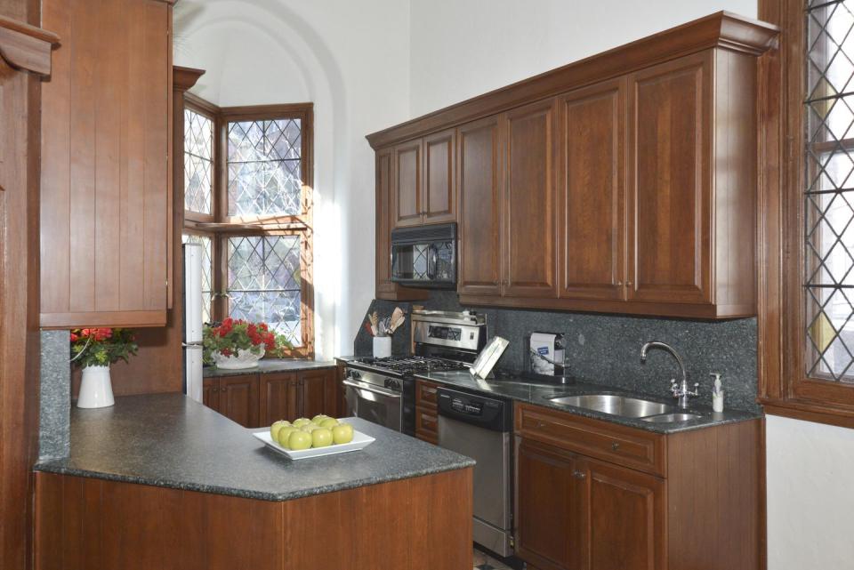 The adjacent kitchen features wooden cabinets that match the windows.