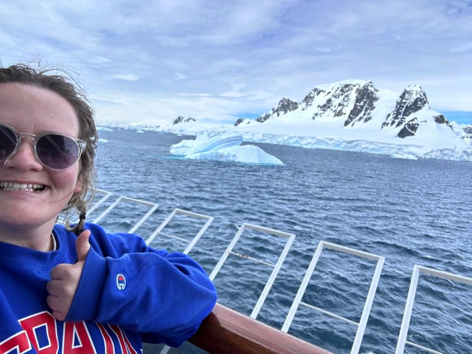 Erin Yarnall giving a thumbs up in front of a glacier while on a cruise ship