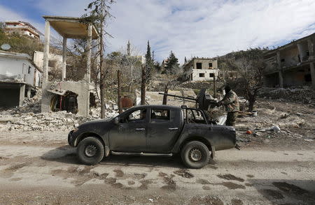 Forces loyal to Syria's President Bashar al-Assad drive a vehicle mounted with an anti-aircraft weapon in the town of Rabiya after they recaptured the rebel-held town in coastal Latakia province, Syria January 27, 2016. REUTERS/Omar Sanadiki
