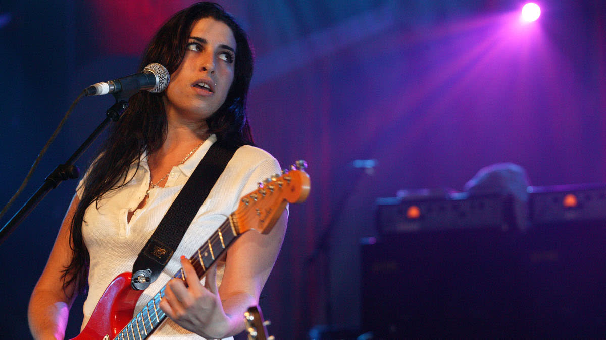  Amy Winehouse playing her red Fender Strat on stage. 
