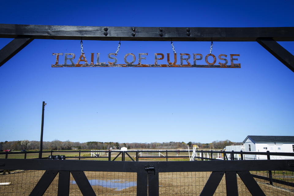 A sign hangs over a gate at the Trails of Purpose horse farm in Chesapeake, Va. on Wednesday, March 15, 2023. The nonprofit mental health counseling organization serves more than 100 service members and veterans each week." (AP Photo/John C. Clark)