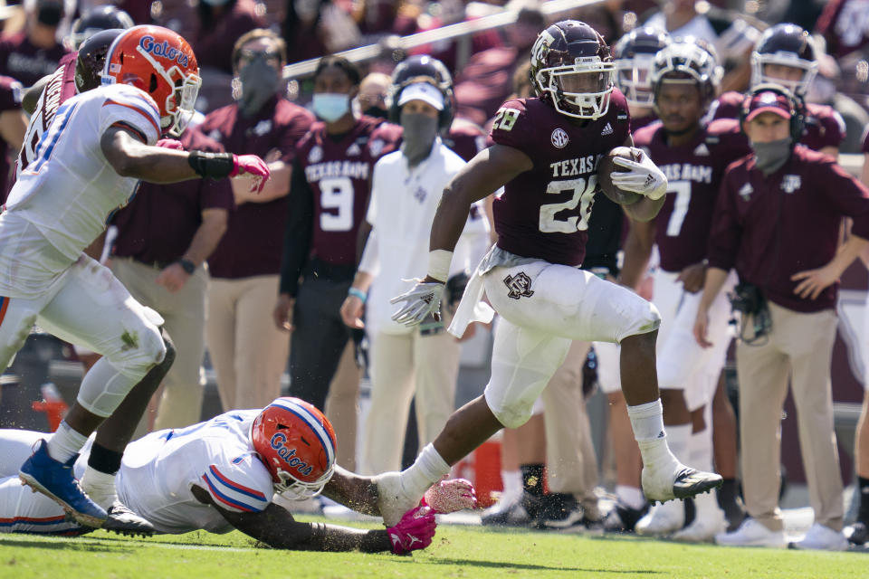 Texas A&M running back Isaiah Spiller (28) steps away from Florida linebacker Brenton Cox Jr. (1) during a run down the sideline during the second half of an NCAA college football game, Saturday, Oct. 10, 2020. in College Station, Texas. (AP Photo/Sam Craft)