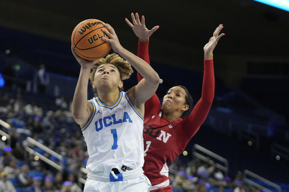 UCLA guard Kiki Rice, left, shoots as Cal State Northridge forward Olivia Smith defends during the first half of an NCAA college basketball game Thursday, Dec. 7, 2023, in Los Angeles. (AP Photo/Mark J. Terrill)