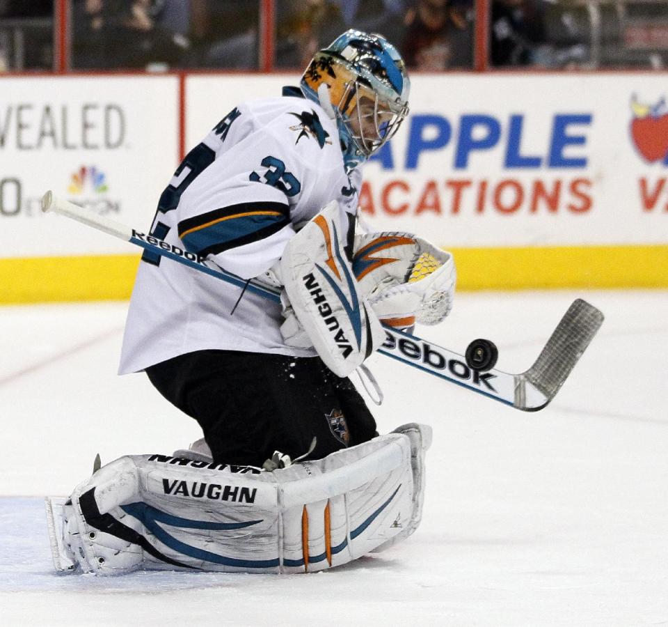 San Jose Sharks' Alex Stalock deflects a shot with his stick during the second period of an NHL hockey game against the Philadelphia Flyers, Thursday, Feb. 27, 2014, in Philadelphia. The Sharks won 7-3. (AP Photo/Tom Mihalek)