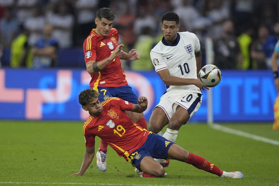 From left, Spain's Lamine Yamal, Spain's Alvaro Morata and England's Jude Bellingham fight for the ball during the final match between Spain and England at the Euro 2024 soccer tournament in Berlin, Germany, Sunday, July 14, 2024. (AP Photo/Matthias Schrader)