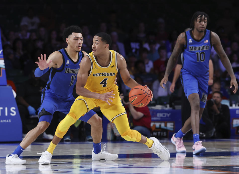 In a photo provided by Bahamas Visual Services, Michigan's Nimari Burnett is guarded by Memphis' Jahvon Quinerly during an NCAA college basketball game in the Battle 4 Atlantis at Paradise Island, Bahamas, Wednesday, Nov. 22, 2023. (Tim Aylen/Bahamas Visual Services via AP)
