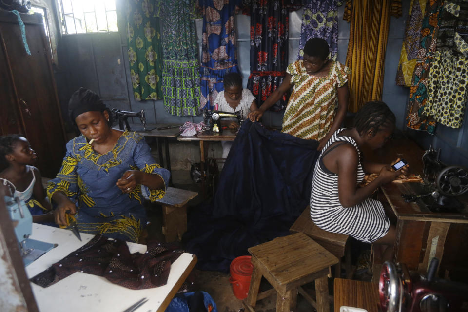 Women sew clothes at a shop in Conakry, Guinea, Thursday, Sept. 9, 2021. Guinea's new military leaders sought to tighten their grip on power after overthrowing President Alpha Conde, warning local officials that refusing to appear at a meeting convened Monday would be considered an act of rebellion against the junta. (AP Photo/Sunday Alamba)