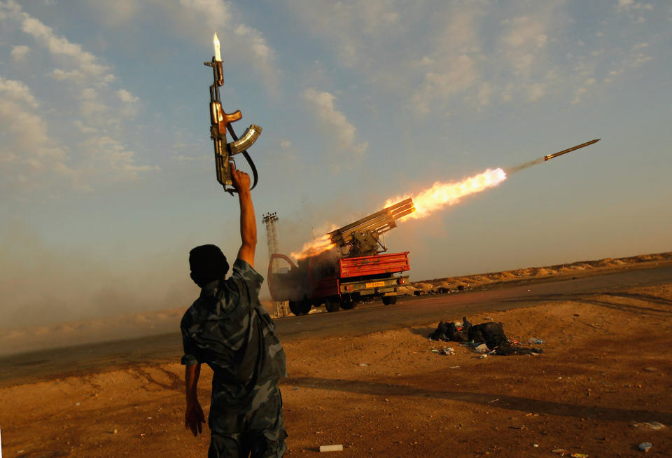 <p>A rebel fighter celebrates as his comrades fire a rocket barrage toward the positions of troops loyal to Libyan ruler Muammar Gaddafi April 14, 2011 west of Ajdabiyah, Libya. Rebels exchanged artillery and rocket fire with loyalist troops west of Ajdabiyah April 14 as the confict engulfing Libya continued. (Photo by Chris Hondros/Getty Images) </p>