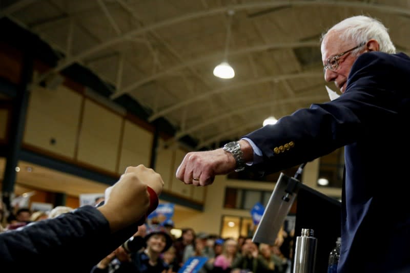 FILE PHOTO: Democratic U.S. presidential candidate Senator Bernie Sanders gives a fist bump to people in the audience at the end of a campaign town hall event in Exeter