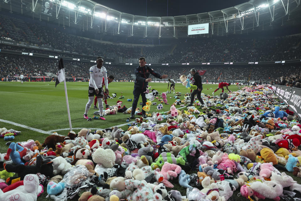 Fans throw toys onto the pitch during the Turkish Super League soccer match between Besiktas and Antalyaspor at the Vodafone stadium in Istanbul, Turkey, Sunday, Feb. 26, 2023. During the match, supporters threw a massive number of soft toys to be donated to children affected by the powerful earthquake on Feb. 6 on southeast Turkey. (AP Photo)