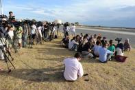 Members of the media sit camped out near the runway waiting for the return of an RAAF Orion aircraft at Pearce Air Base in Bullsbrook, 35 kms north of Perth, on March 24, 2014