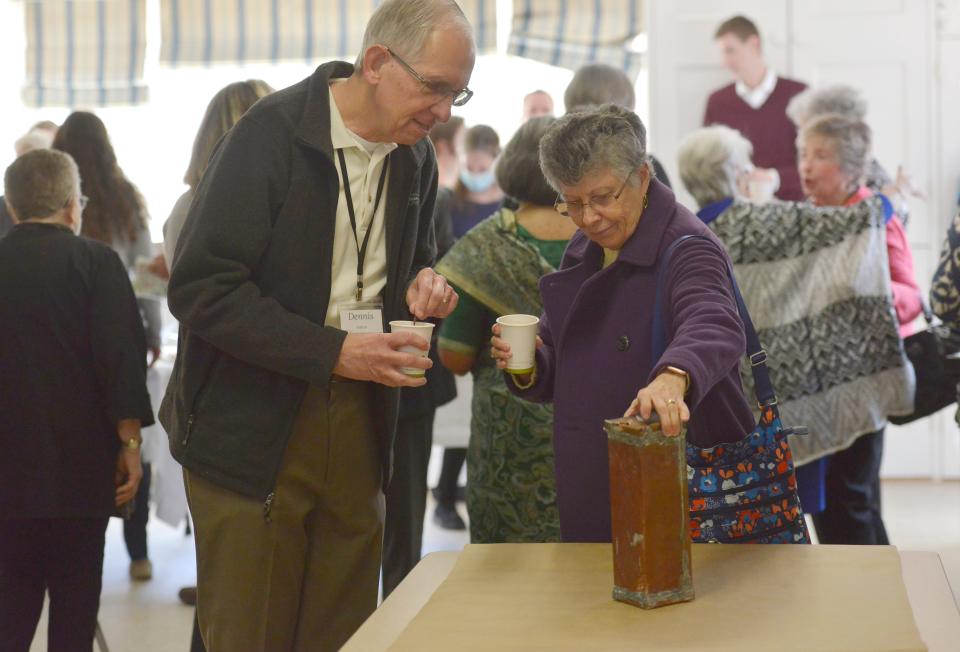 Dennis and Cathy Anton, of Mashpee, take a closer look at a time capsule in Cotuit before it was opened April 24.