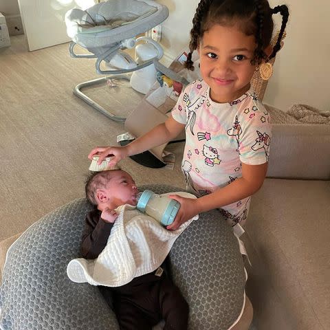 Kylie Jenner/Instagram Stormi feeds her baby brother Aire