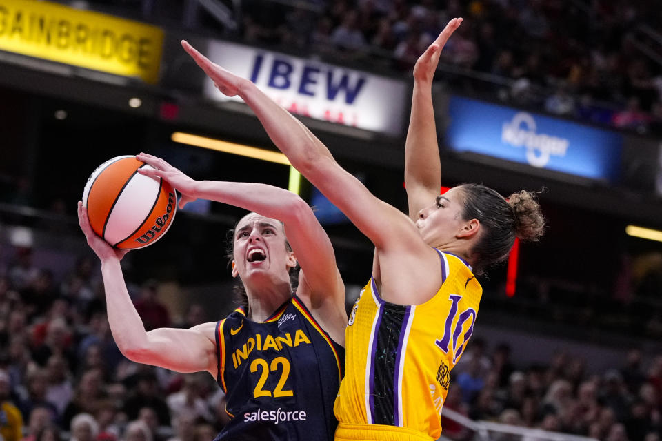 FILE - Indiana Fever guard Caitlin Clark (22) shoots around Los Angeles Sparks guard Kia Nurse (10) in the first half of a WNBA basketball game in Indianapolis, Tuesday, May 28, 2024. (AP Photo/Michael Conroy, File)